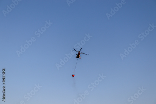 helicopter fly over the sky and extinguishes a fire