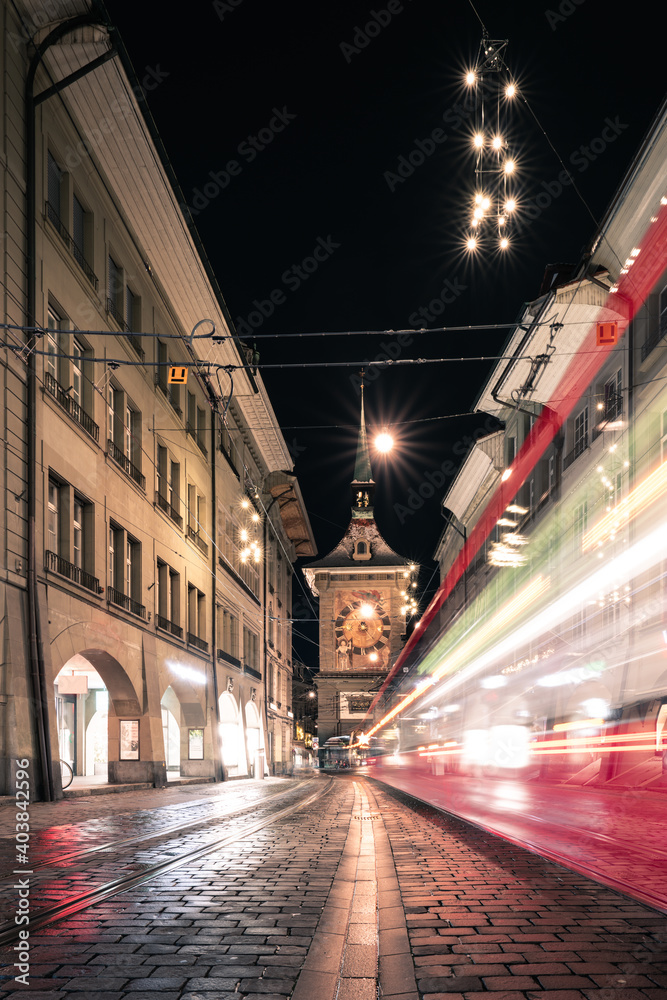 Fototapeta premium Ein Foto der Altstadt von Bern in der Schweiz mit Sicht auf den Zytglogge Turm und ein Tram von Bernmobil im Winter bei Nacht
