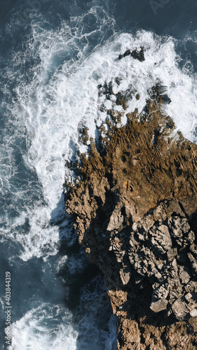 ocean waves hit the rock, topshot aerial view in Portugal, vertical, 9:16