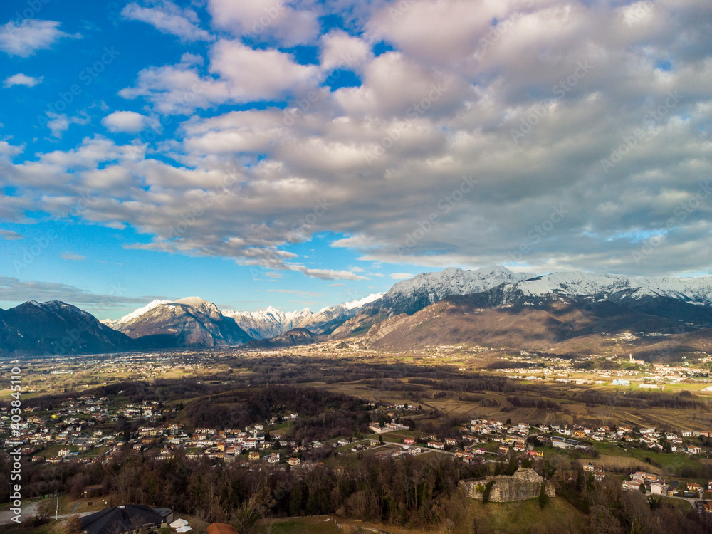 Panoramic from above on the ancient village of San Lorenzo di Buja and on the snow-capped mountains.