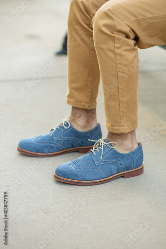 A pair of colorful blue navy formal mens shoes with wingtip fashion  dress with Khakis.