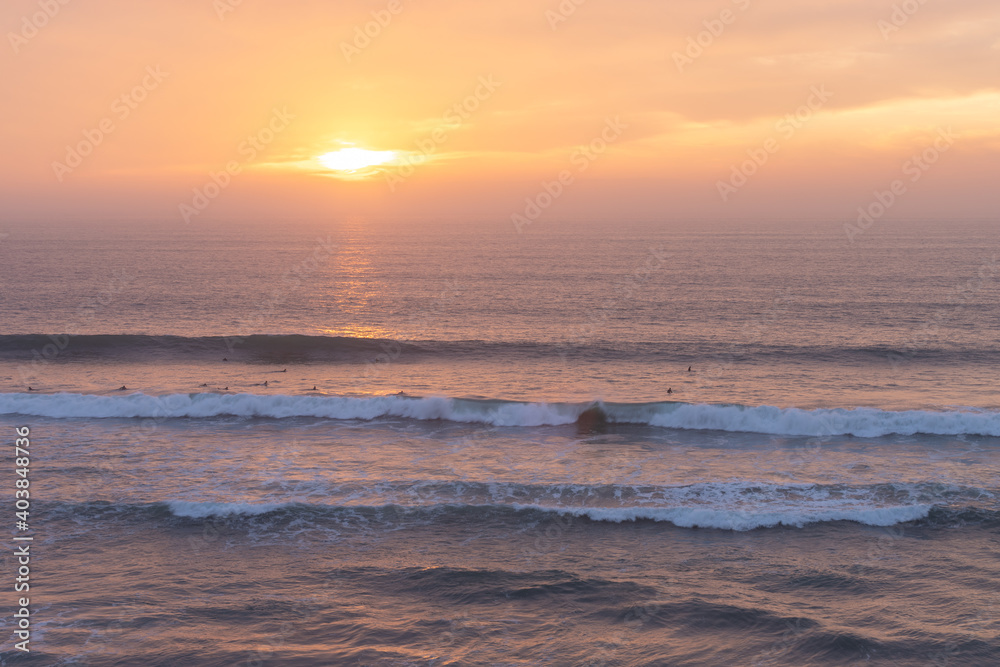 Surfers catching the last waves of the day.
