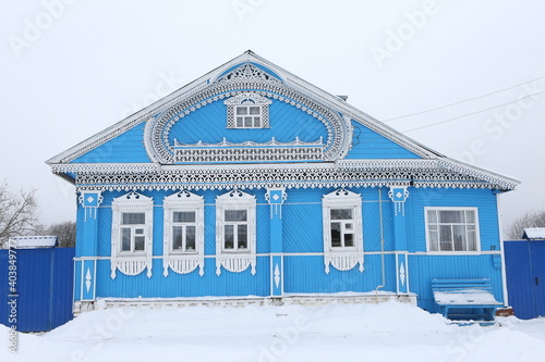 Vintage wooden rural house in Dunilovo village in Ivanovo region, Russia. Building facade; ornamental windows with carved frames. Russian traditional national folk style in architecture. Countryside photo