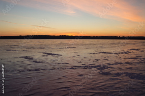 Ice on the lake at sunset. Winter background. Copy Space