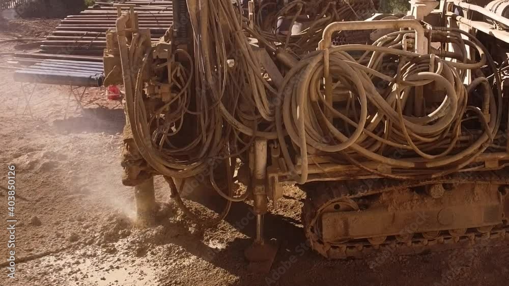Compact pile driver at construction site. Drilling the ground creates a lot of dust. Compact pile driver at construction site. Drilling the ground creates a lot of dust.