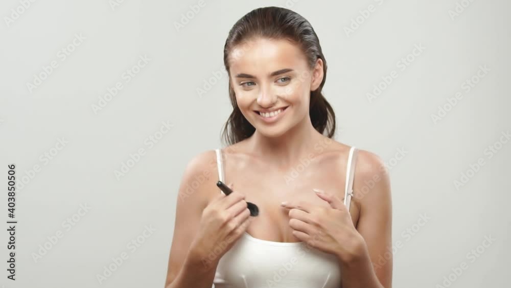 cute girl powdering breast with brush