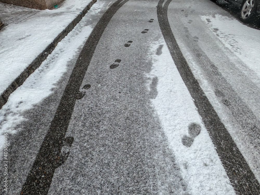 snowy road with tracks and footprints snowy road with tracks and footprints