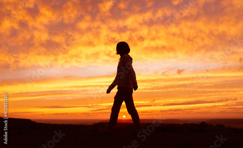 Traveler girl silhouette. Young woman walks during the sunset.