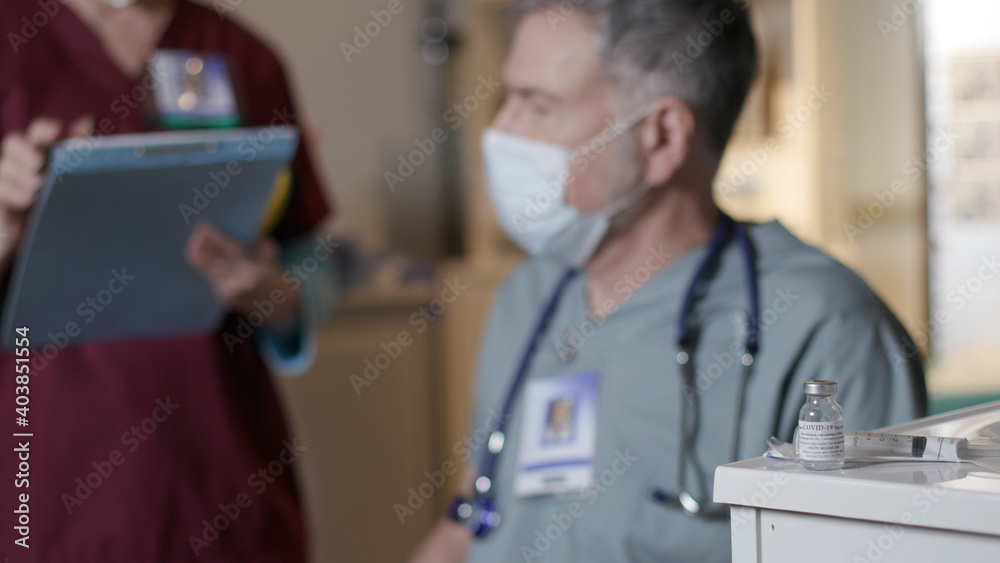 A nurse prepares a doctor to receive a vaccination against SARS-CoV-2