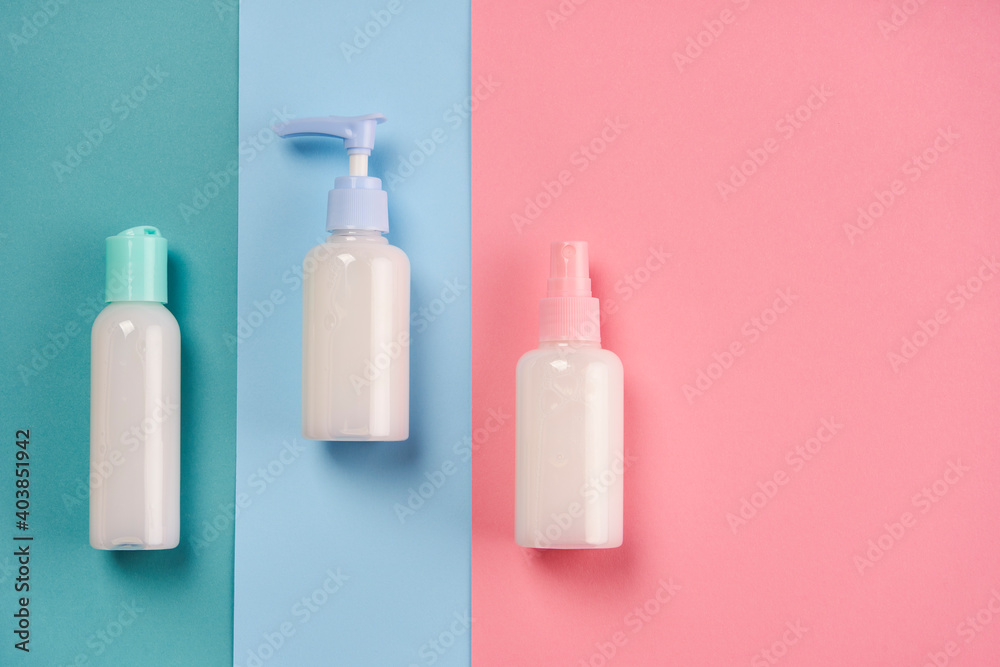 Packagings of cream, lotion, gel, facial foam or skin care on blue and pink background with copy space. Cosmetic beauty product branding mockup Packagings of cream, lotion, gel, facial foam or skin care on blue and pink background with copy space. Cosmetic beauty product branding mockup