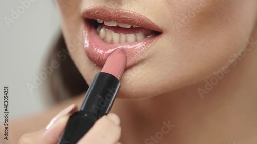 close-up of woman applying lipstick