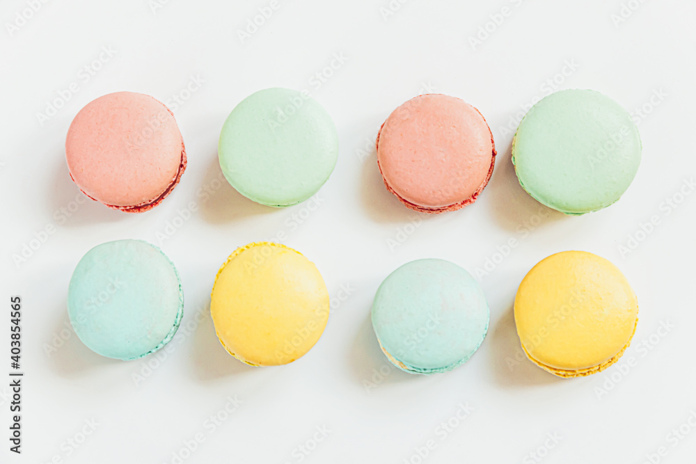 Sweet almond colorful pastel pink blue yellow green macaron or macaroon dessert cake isolated on white background. French sweet cookie. Minimal food bakery concept. Flat lay top view, copy space Sweet almond colorful pastel pink blue yellow green macaron or macaroon dessert cake isolated on white background. French sweet cookie. Minimal food bakery concept. Flat lay top view, copy space