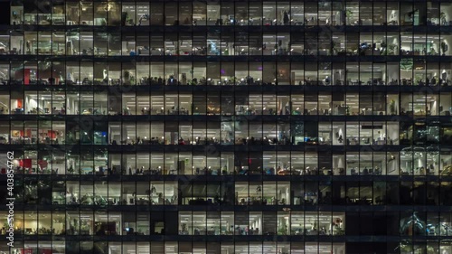 Zooming out view of office windows with working people