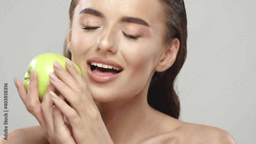 cheerful girl stroking her face with fresh apple cheerful girl stroking her face with fresh apple