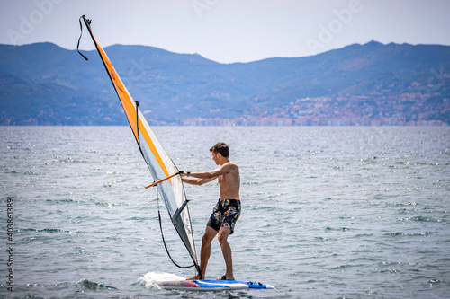 Young male learning how to surf on a windsurf