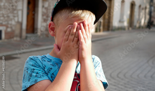 Obrażone dziecko, chłopiec na ulicy. photo