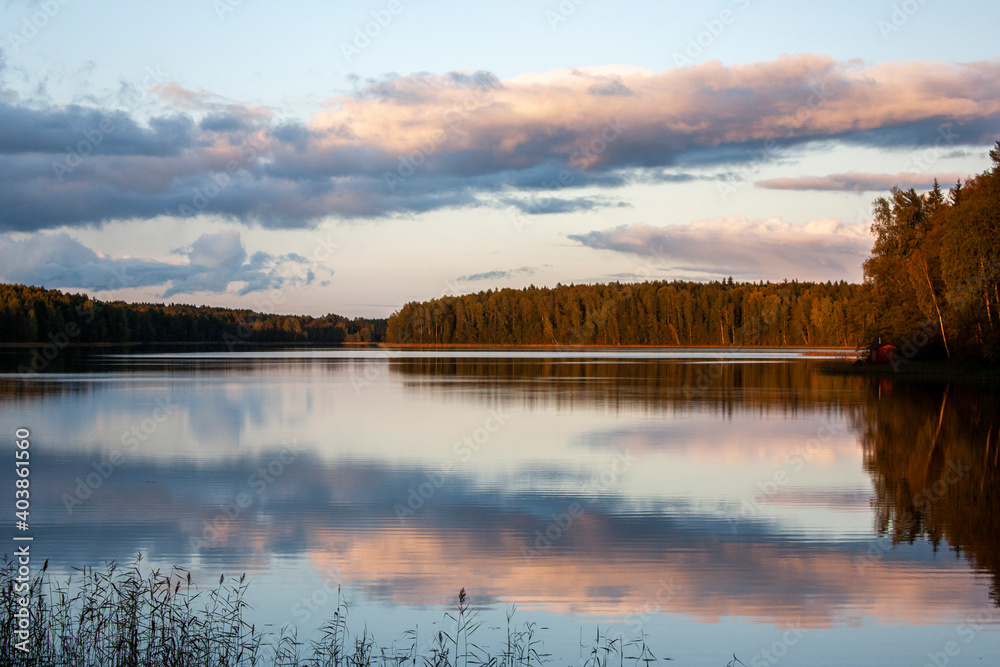 Sunrise on the lake. Clouds over the water in the early morning in the light of the sun. View of lake in the early morning in autumn.