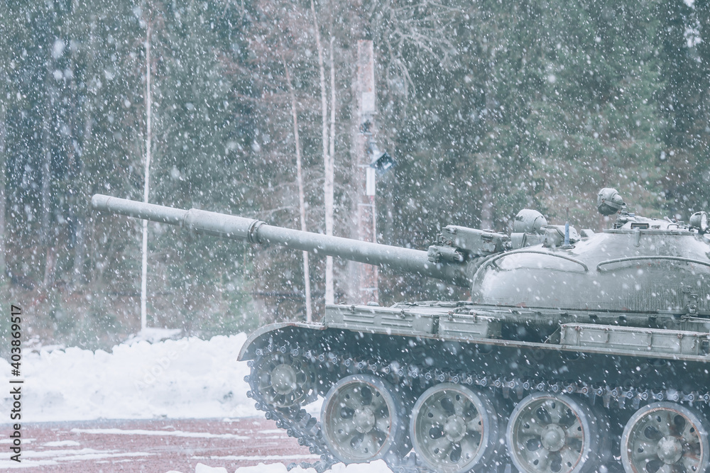 Tank during a snowfall. Army tank, side view Tank during a snowfall. Army tank, side view