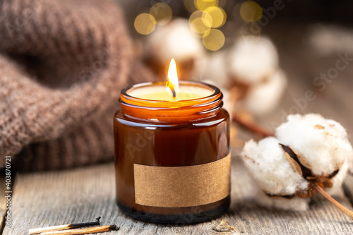 Burning candle in a glass jar with label mock up photo