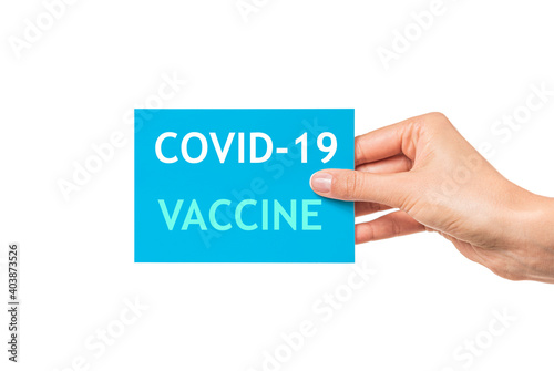 Card with the inscription Covid-19 vaccine in a female hand isolated on white.