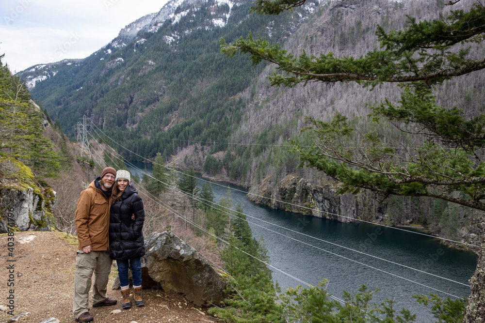 Cheerful man and woman together outdoors as a couple traveling in nature and taking in the Washington state scenery above the Skagit River
