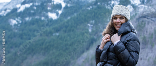 Canvas Print A woman outside in nature takes in the view of beautiful, snow covered mountains