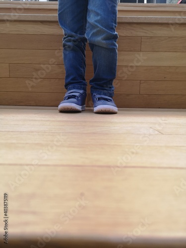 Pieds d'un enfant avec un jean et chaussures bleues © ElMehdi