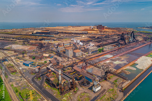 Aerial View of Vast Industrial Landscape. Steel Mills and Heavy Industry, Rail Lines, Bridges, Shipping Canal, Harbor, etc.