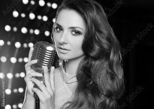 Gorgeous singer woman in with retro microphone on restaurant stage