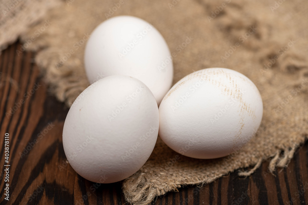 Chicken eggs on a background of homespun fabric with a rough texture. Close-up, selective focus. Chicken eggs on a background of homespun fabric with a rough texture. Close-up, selective focus.