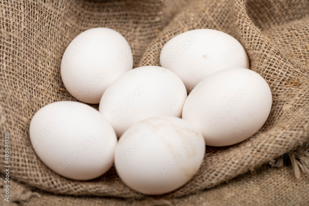 Chicken eggs on a background of homespun fabric with a rough texture. Close-up, selective focus. Chicken eggs on a background of homespun fabric with a rough texture. Close-up, selective focus.