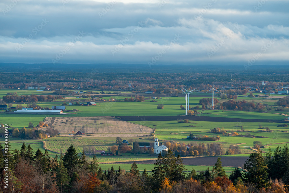 Late autumn color scene with low casting light over horizon landscape of forests and fields with windmills. Magnificent view from mountain Omberg in East of Sweden. Late autumn color scene with low casting light over horizon landscape of forests and fields with windmills. Magnificent view from mountain Omberg in East of Sweden.