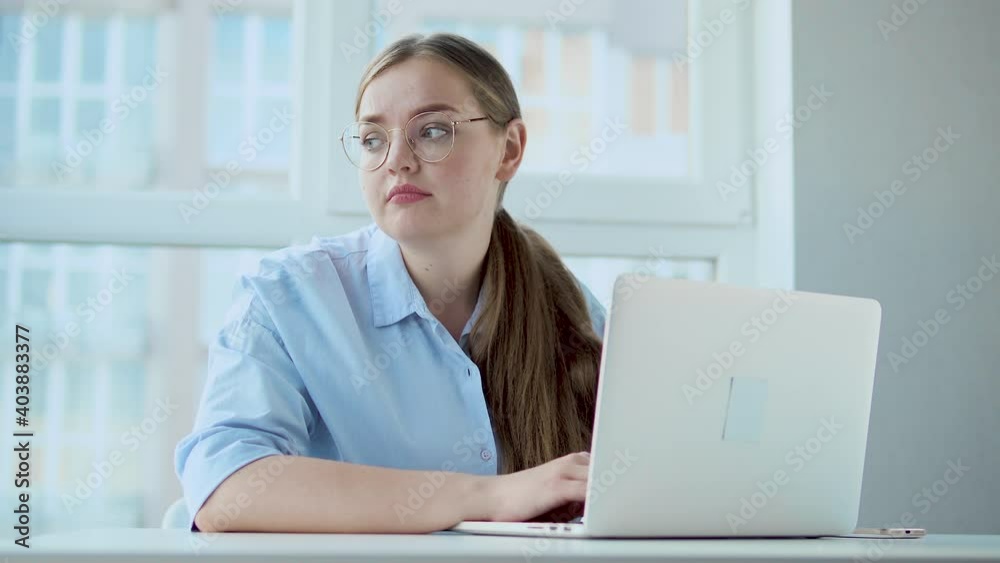 Unhappy woman office worker cant concentrate on her job sitting with laptop Unhappy woman office worker cant concentrate on her job sitting with laptop