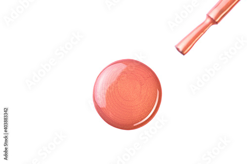 A drop of beige nail polish with a brush on a white isolated background.