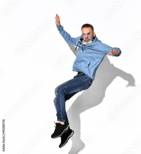 Picture a man with a beard in stylish sunglasses full-length fun, it jumps high above the ground or falls from a height