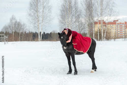Young woman on horseback riding outdoors in winter