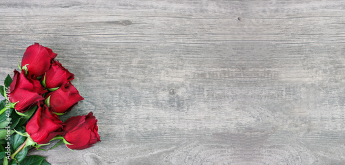 Valentine's Day Holiday Love Concept with Beautiful Red Roses Shot From Direcly Above in Corner Over Wood Background Texture with Copy Space photo