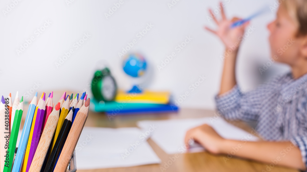 Boy, pupil sitting at the table and studying from home Boy, pupil sitting at the table and studying from home