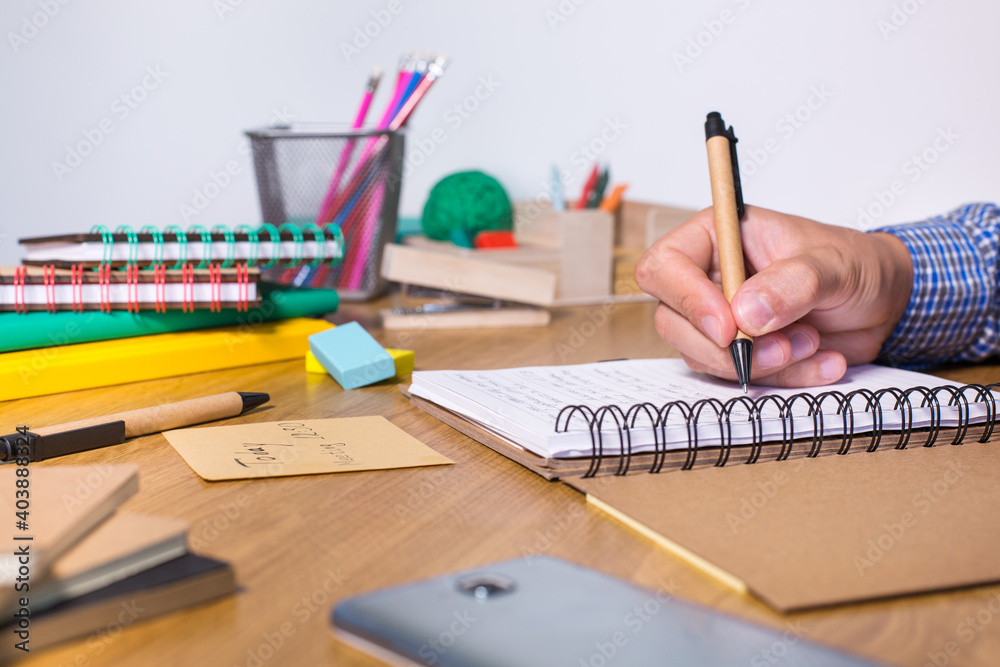 Young man sitting at the table and studying from home Young man sitting at the table and studying from home