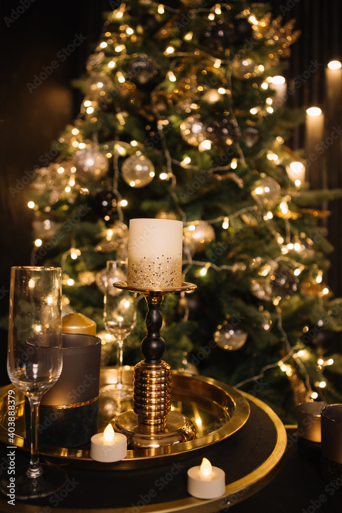 shiny christmas candles and glass champagne glasses on a gold tray against a sparkling christmas tree background, new year 2023, 2024 shiny christmas candles and glass champagne glasses on a gold tray against a sparkling christmas tree background, new year 2023, 2024