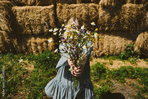 Cottagecore, Countryside aesthetics, Farming, Farmcore, Countrycore, slow life. Young girl in peasant dress and with flowers enjoying nature on country farm. Modern rural fantasy, pastoral aesthetic photo