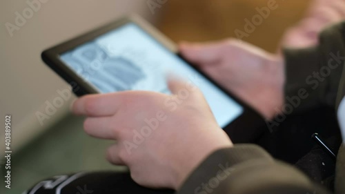 School boy kid using digital ebook reader at home,new book reading technology 