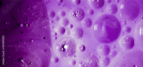 beautiful background of paint bubbles floating on water with mix of oil purple