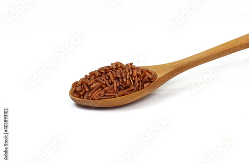 Red wild rice in a wooden spoon isolated on white background