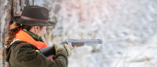 Foto A young beautiful hunter woman on hunt in forest with rifle on the shoulder