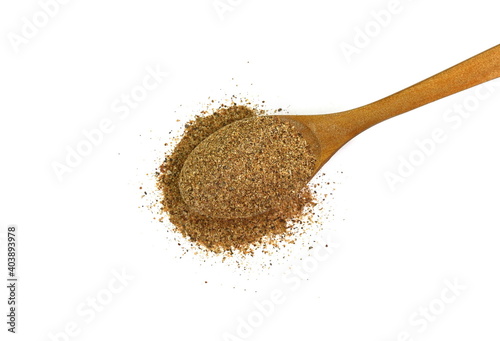 Ground carob powder (Ceratonia siliqua) in a wooden spoon isolated on white background. Ripe carob pods and carob powder, can be used as a substitute for cocoa.
