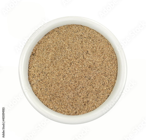 Ground carob powder (Ceratonia siliqua) in a bowl isolated on white background. Ripe carob pods and carob powder, can be used as a substitute for cocoa.