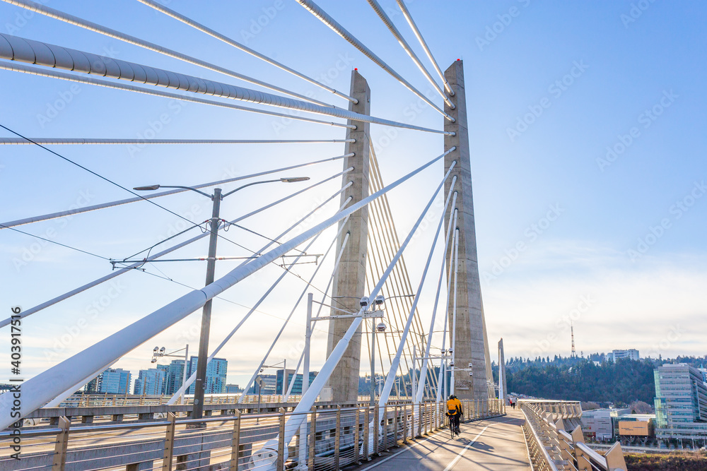 People walk over the Tilikum Crossing Bridge near sunset in Portland, Oregon People walk over the Tilikum Crossing Bridge near sunset in Portland, Oregon