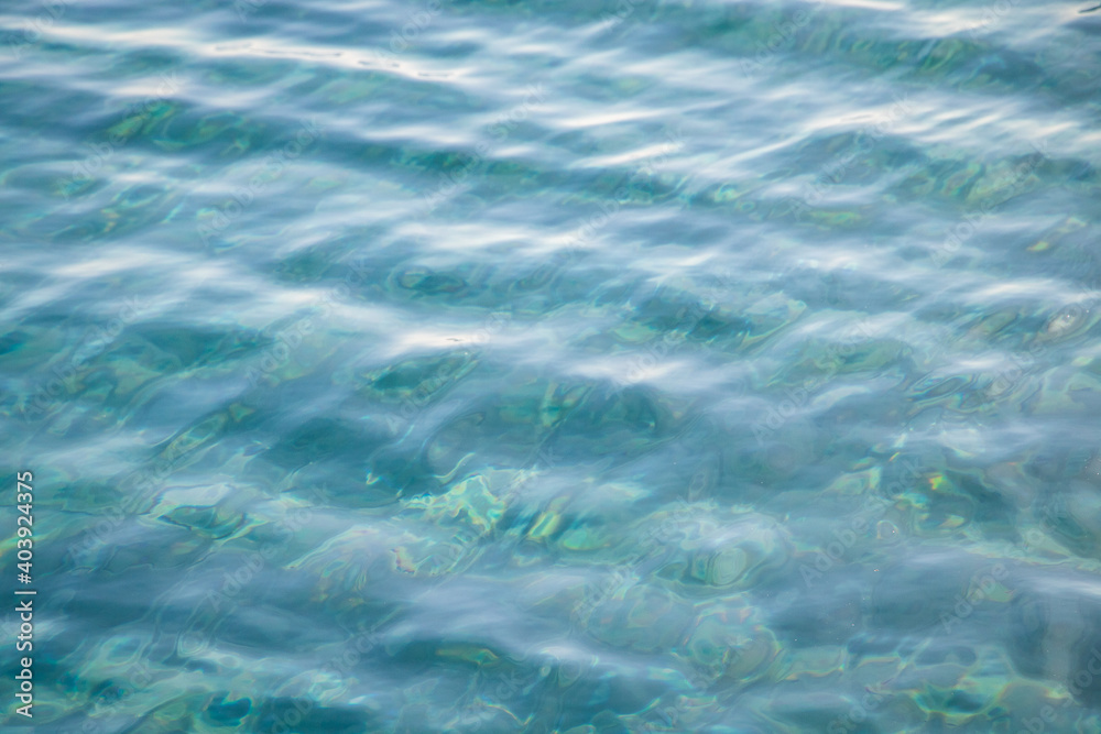 Obraz premium Ripples on clear tropical blue water in the sea.