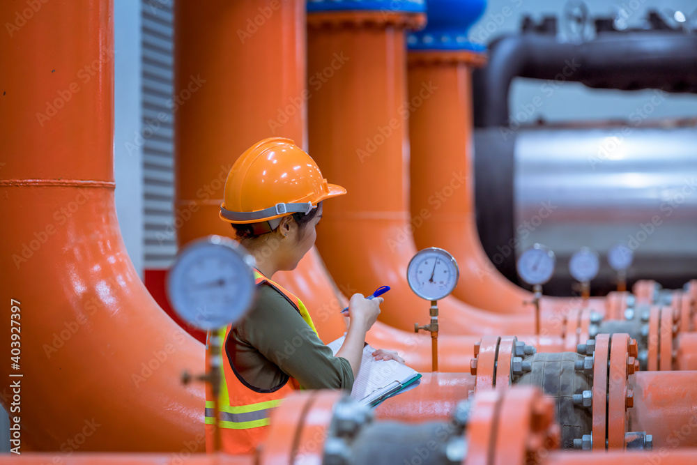 Fototapeta premium Portrait industry worker under checking the industry cooling tower air conditioner is water cooling tower air chiller HVAC of large industrial building to control air system